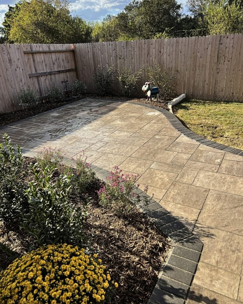 Vision Grounds crew installing a curved paver border with precision cutting