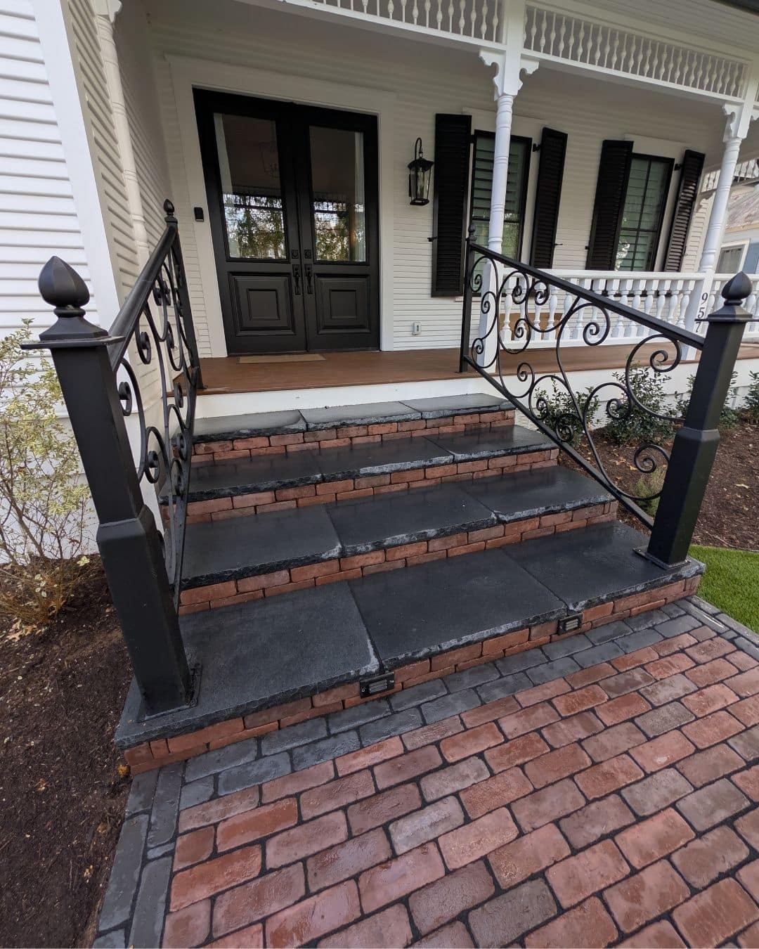 Custom masonry entrance steps with limestone treads and vertical paver risers