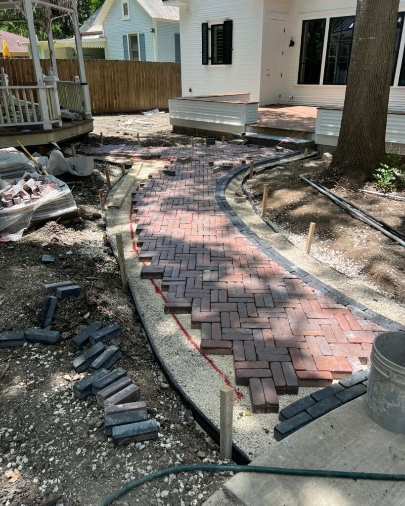 Hand-laying herringbone paver pattern process on a historic New Braunfels property