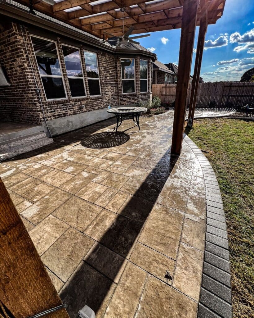 High-end interlocking stone patio with a dark charcoal soldier course border