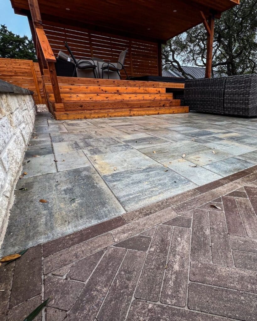 Close-up of Beacon Hill Smooth Fossil pavers transitioning into a complex Mattoni herringbone pattern with tight joints