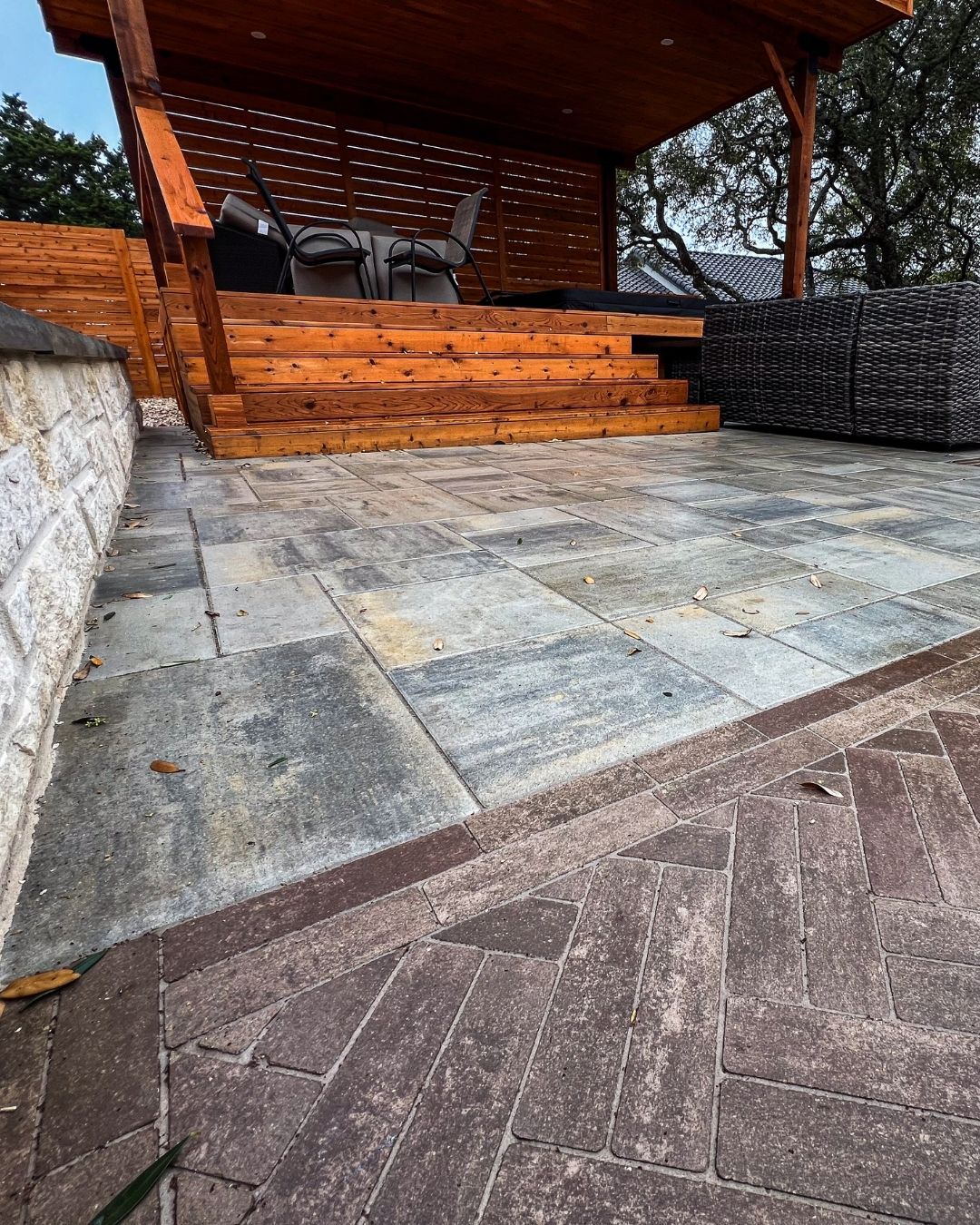 Close-up of Beacon Hill Smooth Fossil pavers transitioning into a Mattoni herringbone pattern